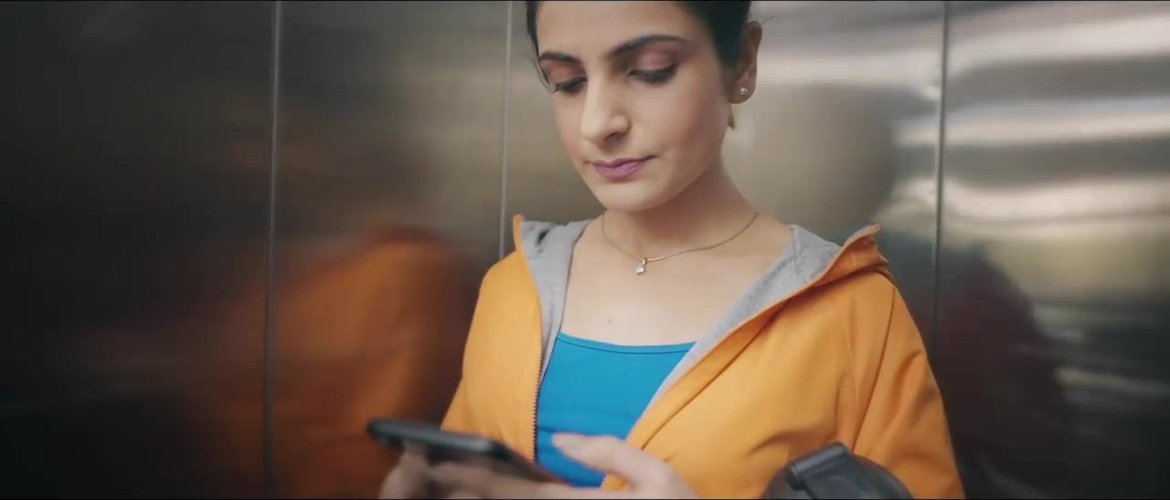 Marks & Spencer campaign still of a woman checking her phone in a lift