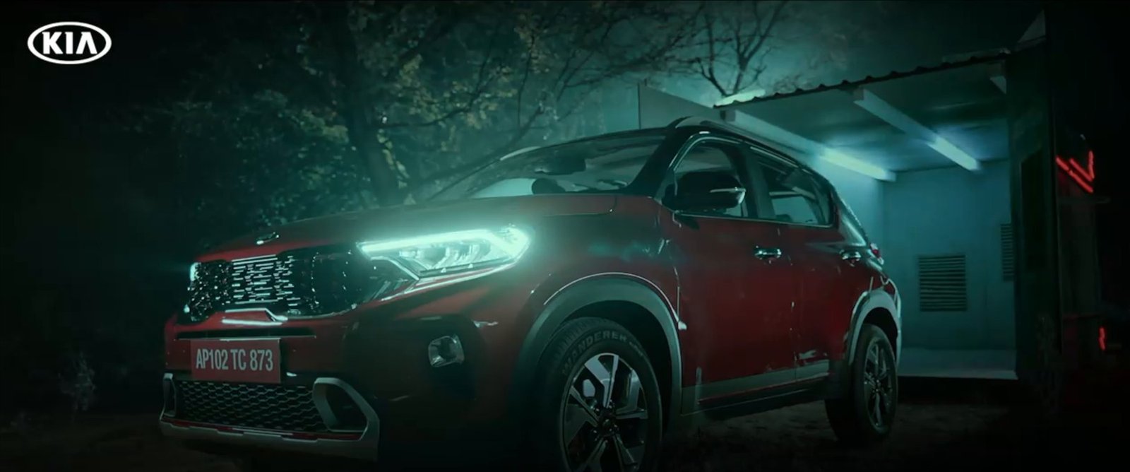 Red Kia Sonet lit up in a dark garage